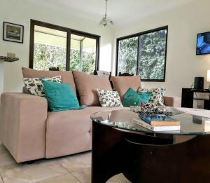 下博克特Casa Mirango Boquete的客厅配有粉红色的沙发和桌子