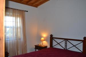 Porto MartinsAdega Mendes的一间卧室配有一张床和一扇带灯的窗户