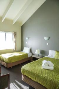 奥克兰机场庄园旅馆的酒店客房设有两张床和窗户。