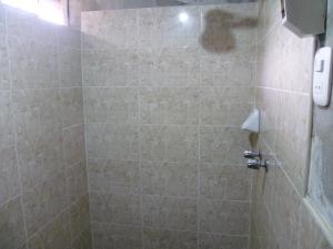 奥克萨潘帕HOSPEDAJE CAMPOS ELÌSEOS的一间带淋浴的浴室和瓷砖墙