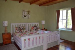 FranklinWhispering Spirit Holiday Cottages & Mini Ponies的卧室配有白色的床和2扇窗户。