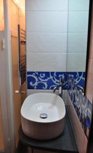 特雷卡斯塔尼NICE mini House - tra l'Etna Catania Taormina e il Mare的浴室铺有蓝色和白色瓷砖,配有白色水槽。