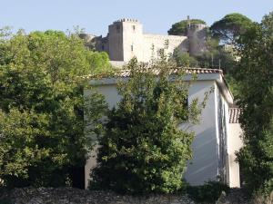 BoissièresGîte Les Clapas的一座白色车库,后面有一座城堡