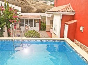 洛斯雷亚莱霍斯Casa Buganvilla的一座大型蓝色游泳池,位于房子旁边