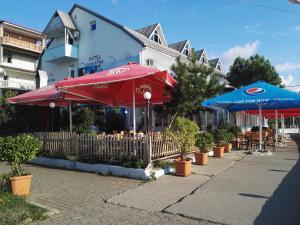 科布列季Apartment Agmashenebeli 99的餐厅配有红色和蓝色的遮阳伞和桌子