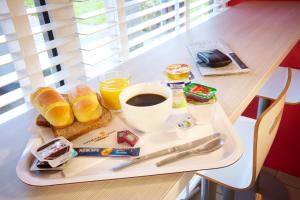 斯特拉斯堡贡比涅 - 亚克斯普瑞米尔经典酒店的桌上的早餐食品和咖啡托盘