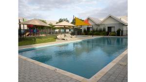 巴瑟尔顿FortyTwo - Oceanside Retreat Busselton的房屋旁的游泳池配有椅子和遮阳伞