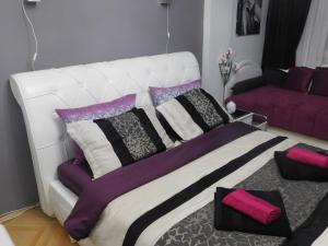 尼什Velvet Lux Apartment的白色的床,带紫色和黑色枕头