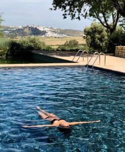 阿尔科斯-德拉弗龙特拉Cortijo Bablou - Maison de vacances的躺在游泳池里的女人