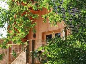 特雷尼Ecolodge Beauregard的一座带围栏和树木的木屋