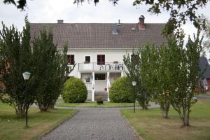 舍夫德Pensionat Klåvasten的前面有树木的大白色房子