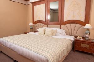 清迈清迈广场酒店的一间卧室配有一张大床和镜子