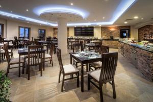 Sīdī ‘Abd ar RaḩmānAura Resort Sidi Abd El Rahman El Alamein的一间带木桌椅的餐厅和一间酒吧