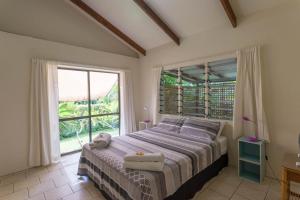拉罗汤加Mango Cottage的一间卧室设有一张床和一个大窗户