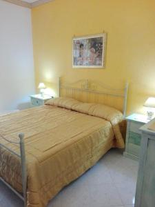 雷阿尔蒙特Anemone della Scala dei Turchi的黄色客房内的一间卧室配有一张大床
