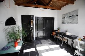 沃尔克姆B&B de Garaazje的一间设有黑色门、一张桌子和椅子的房间