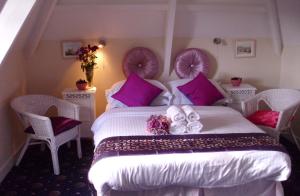 彭赞斯埃斯托利尔酒店的卧室配有一张带紫色枕头的大型白色床。