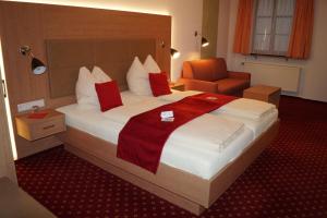 锡格马林根Hotel Traube的酒店客房带一张大床和一把椅子
