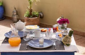 马拉喀什Riad Villa Harmonie的餐桌,带食物和橙汁盘