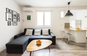 马德里Apartamento en SOL, Madrid Centro的客厅配有黑色沙发和桌子
