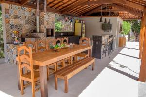 蒂拉登特斯Pousada Recanto das Araras的厨房以及带木桌和椅子的用餐室。