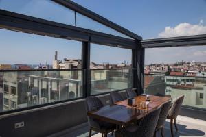 伊斯坦布尔Meretto Hotel LALELİ的一间带桌椅和大窗户的用餐室