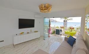 贝尼多姆Apartamento Daniela的带沙发和电视的客厅,享有海景。