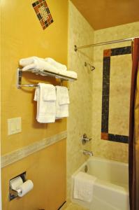 圣塔克拉瑞塔圣塔克拉瑞塔汽车旅馆的浴室配有浴缸、淋浴和毛巾。