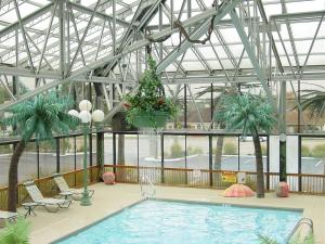 弗洛伦斯怀尔德伍德酒店的一座种植了棕榈树和植物的大型室内游泳池
