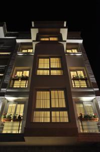 伊兹密尔德卡艾维勒里酒店的一座高大的建筑,晚上有窗户照亮