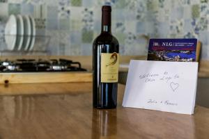泰拉奇纳Casa Lupita的一张桌子上放着一瓶葡萄酒,还有一张便条