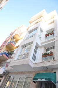 伊兹密尔德卡艾维勒里酒店的白色的建筑,窗户上装有花盆