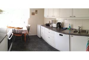 HerandApartment in Herand, Hardanger的厨房配有白色橱柜、水槽和桌子