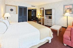 蒙特雷方迪多拉蒙特雷公园假日酒店的酒店客房设有一张白色大床和椅子