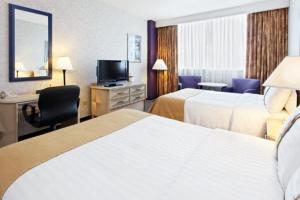 蒙特雷方迪多拉蒙特雷公园假日酒店的酒店客房设有两张床、一张桌子和一台电视。