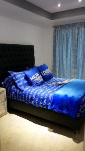 墨西哥城Departamento Privado 3 recamaras的一间卧室配有一张带蓝色床单和枕头的床。