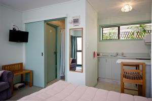 Owaka奥瓦卡汽车旅馆的一间卧室配有床、水槽和窗户