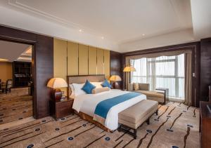 义乌国际博览中心酒店（原：义乌博览皇冠假日酒店）的一间大卧室,配有一张大床和一张沙发
