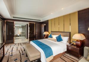 义乌国际博览中心酒店（原：义乌博览皇冠假日酒店）的一间卧室配有一张大床、一张书桌和台灯。