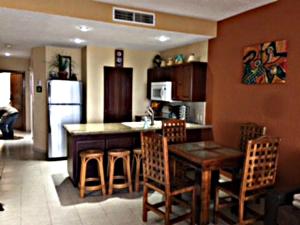 佩尼亚斯科港Sonoran Sea Resort的厨房配有桌椅和冰箱。