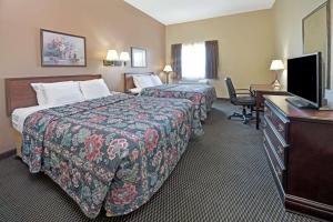 科林斯维尔Days Inn by Wyndham Collinsville St Louis的酒店客房设有两张床、一张桌子和一台电视。