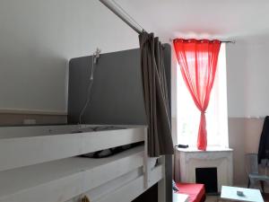 尼斯玛伊奥翁宾馆的一间卧室配有一张带红色窗帘的床