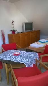 于伯林根Ferienwohnung am Bodensee mit 3 Schlafzimmer über 2 Etage mit kleine Balkon bis 7 Personen的配有桌椅和电视的客房