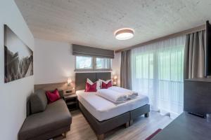 索尔登rechenau LIVING & RELAX的配有一张床和一把椅子的酒店客房