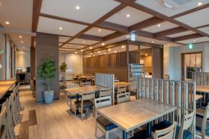 高松高松八岛鲁特酒店的用餐室配有木桌和椅子