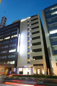 松江市多美迎EXPRESS松江酒店的一座高大的建筑,城市里灯火通明