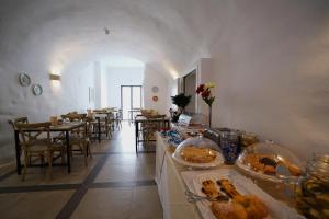 卡洛维诺GH Dimora Sant'Anna-Lofts & Apartments的一间设有桌椅的房间,展示着食物