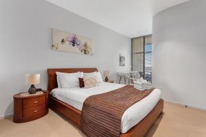 墨尔本Docklands Private Collection - NEWQUAY的一间卧室设有一张大床和一个窗户。