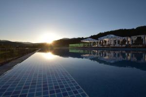 韦林格勒SPA Hotel Infinity Park Velingrad的背景为阳光下的游泳池