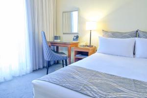 布里斯班布里斯班Soho酒店的配有一张床和一张书桌的酒店客房